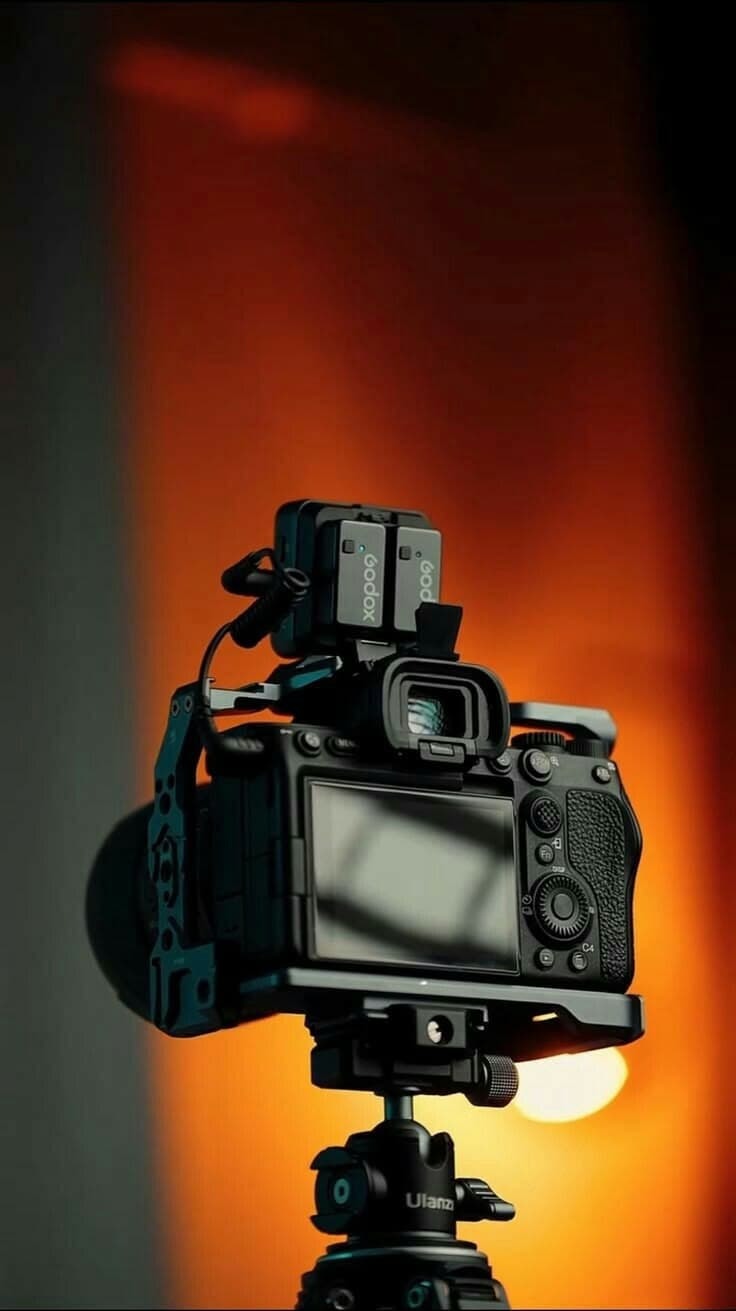 Turuncu ışık önünde tripoda kurulmuş fotoğraf makinesi